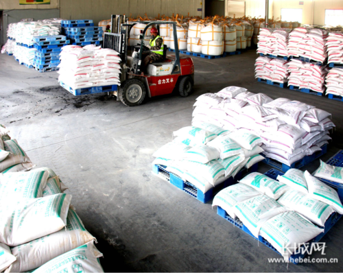 广平县一家饲料生产企业的员工将饲料产品运入成品库.